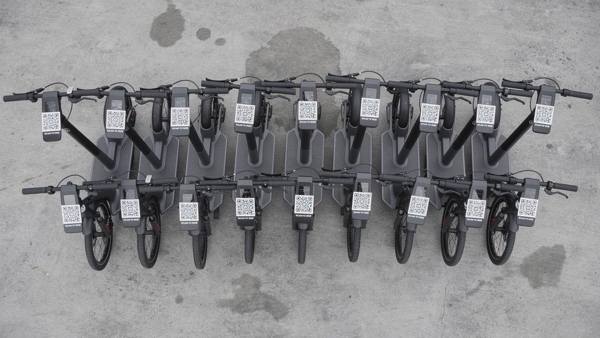 Top-down view of a shared e-scooter and e-bike rack on a plain concrete ground